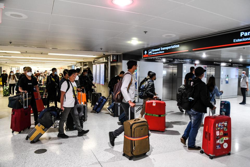 Travelers arrive at Miami International Airport ahead of the long holiday weekend of Memorial Day in Miami on May 26, 2021. (Photo by CHANDAN KHANNA / AFP) 