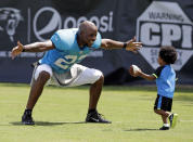 Carolina Panthers' Josh Thomas, left, reaches out to hug his son, Dallas, 2, right, after an NFL football practice at their training camp in Spartanburg, S.C., Tuesday, July 29, 2014. (AP Photo/Chuck Burton)