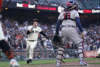 San Francisco Giants' Wade Meckler, left, runs home to score next to Atlanta Braves catcher Travis d'Arnaud during the sixth inning of a baseball game in San Francisco, Sunday, Aug. 27, 2023. (AP Photo/Jeff Chiu)