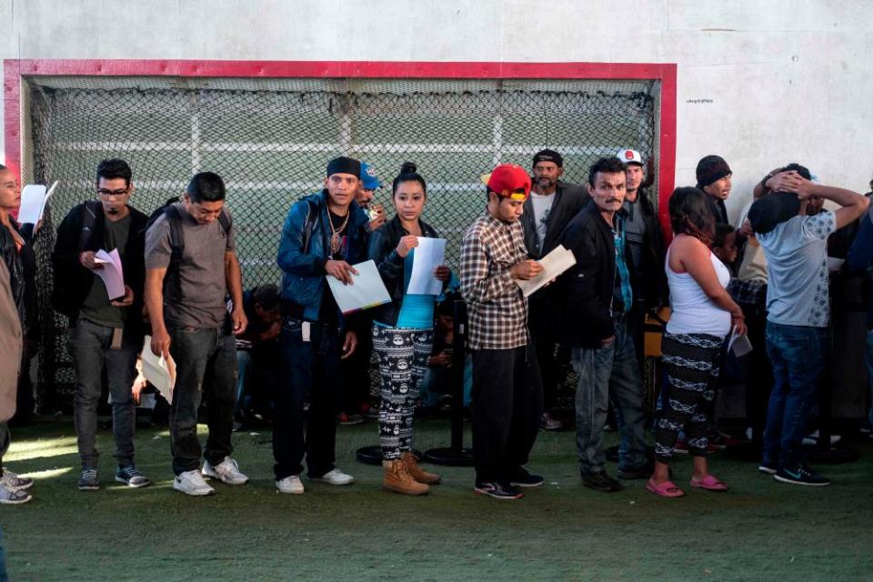 Central American migrants queue as they look for work at a job fair in Tijuana.