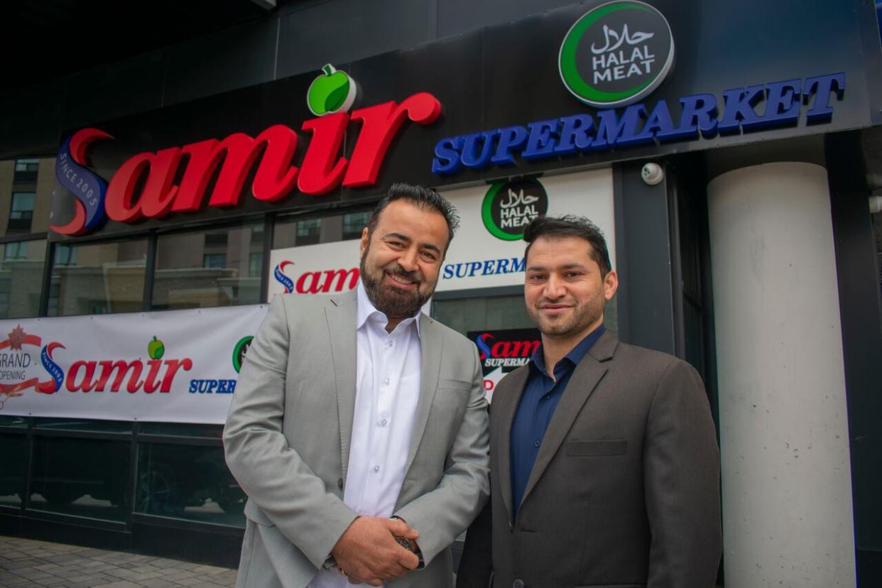 Co-owners Mirways Babakarkhail and Mohammad Asghar stand in front of Samir Supermarket's new downtown location. Babakarkhail started the chain in 2005.  (Bobby Hristova/CBC - image credit)
