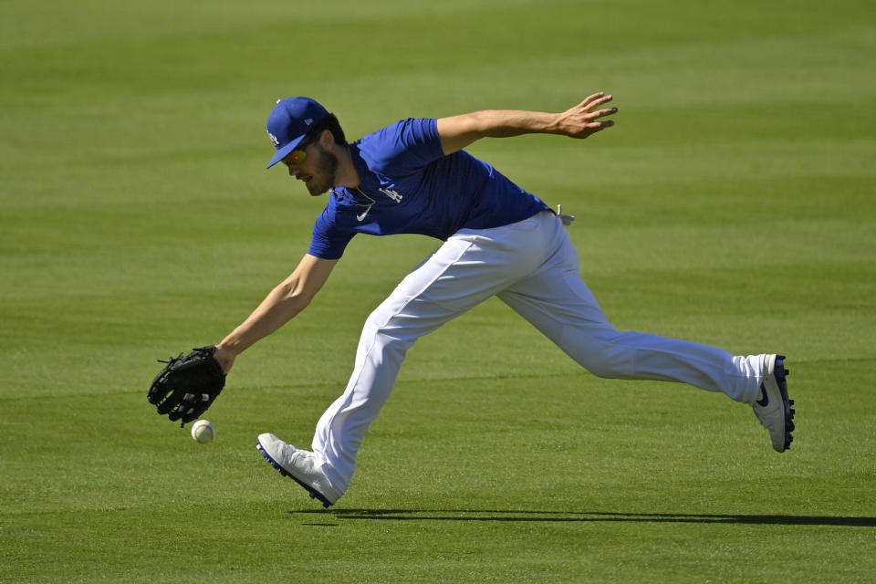 Los Angeles Dodgers center fielder Cody Bellinger fields a ball during the restart of baseball spring training Friday, July 3, 2020, in Los Angeles. (AP Photo/Mark J. Terrill)