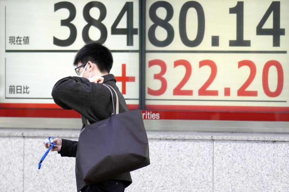 A person walks in front of an electronic stock board showing Japan's Nikkei 225 index at a securities firm Friday, Feb. 16, 2024, in Tokyo. Shares advanced in Asia on Friday, with Tokyo's benchmark Nikkei 225 index trading near a record high, 34 years after it peaked and then plunged with the collapse of Japan's financial bubble. (AP Photo/Eugene Hoshiko)