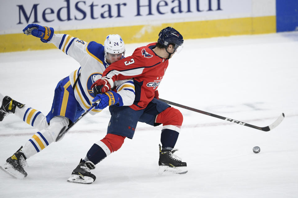 Washington Capitals defenseman Nick Jensen (3) and Buffalo Sabres center Dylan Cozens (24) chase the puck during the first period of an NHL hockey game, Friday, Jan. 22, 2021, in Washington. (AP Photo/Nick Wass)