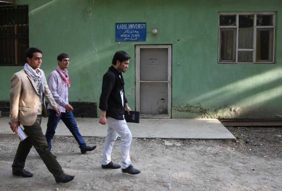 CORRECTS SPELLING OF NAME TO JOHN. Afghan university students walk in front of health clinic at Kabul University where slain American John Gabel worked at Kabul University, teaching computer science classes in his spare time, in Kabul, Afghanistan, Saturday, April 26, 2014. On Saturday, Kabul University vice chancellor Mohammad Hadi Hadayati identified the other two Americans killed in the attack as health clinic administrator John Gabel and his visiting father, Gary, also from the Chicago area. John Gabel’s wife, also an American, was wounded, Hadayati said. “We have lost a great man, a great teacher, a man who was here only to serve the Afghan people,” Hadayati said. John Gabel worked for the U.S.-based charity Morning Star Development and ran a health clinic at Kabul University, teaching computer science classes in his spare time, Hadayati said. John Gabel’s parents were visiting from Chicago, and Hadayati had lunch with the whole family the day before the attack. (AP photo/Rahmat Gul)