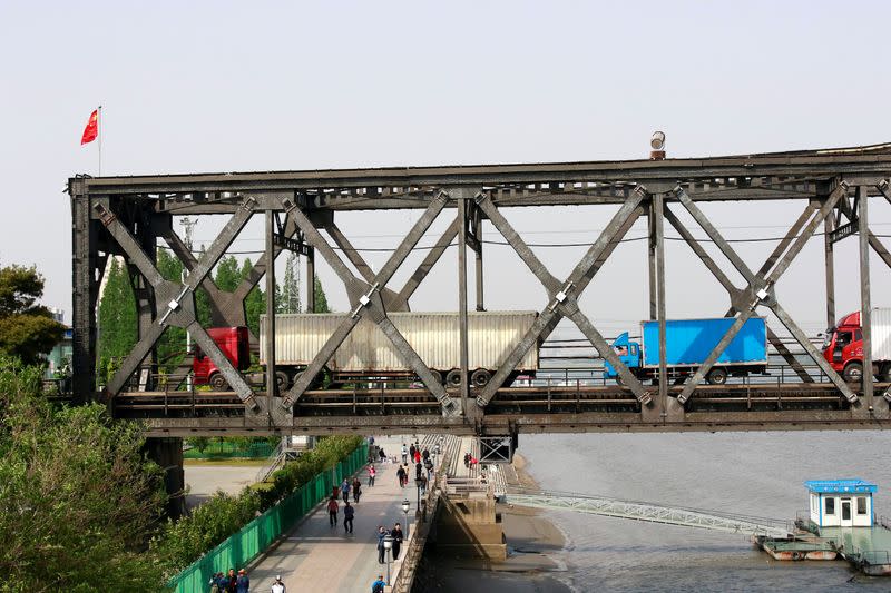 FILE PHOTO: Trucks wait for border inspection at the Chinese end of the Friendship Bridge