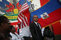 <p>Fandzy Bernadin holds an American flag as he joins with others to mark the 8th anniversary of the massive earthquake in Haiti and to condemn President Donald Trump’s reported statement about immigrants from Haiti, Africa and El Salvador on Jan. 12, 2018 in Miami, Fla. (Photo: Joe Raedle/Getty Images) </p>