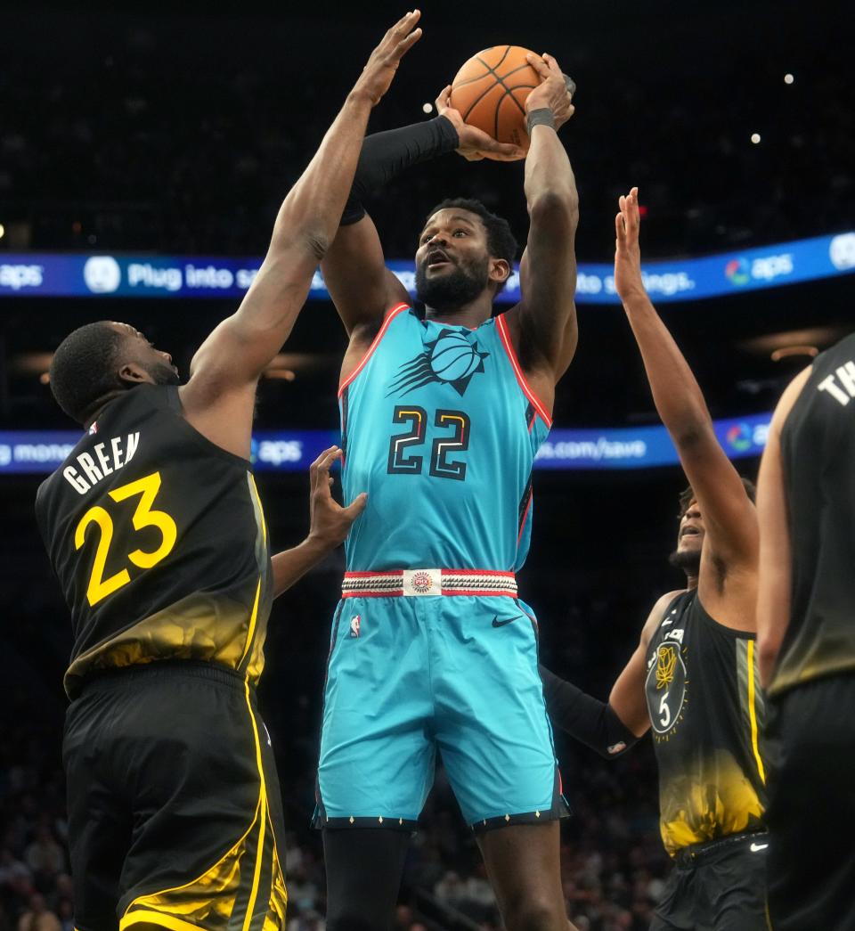 Nov 16, 2022; Phoenix, AZ, USA; Phoenix Suns center 	Deandre Ayton (22) shoots the ball over Golden State Warriors forward Draymond Green (23) at Footprint Center.