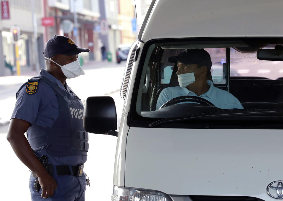 A policeman check the credentials of a motorist in Cape Town, South Africa, Friday, March 27, 2020, after South Africa went into a nationwide lockdown for 21 days in an effort to mitigate the spread to the coronavirus. The new coronavirus causes mild or moderate symptoms for most people, but for some, especially older adults and people with existing health problems, it can cause more severe illness or death(AP Photo/Nardus Engelbrecht)