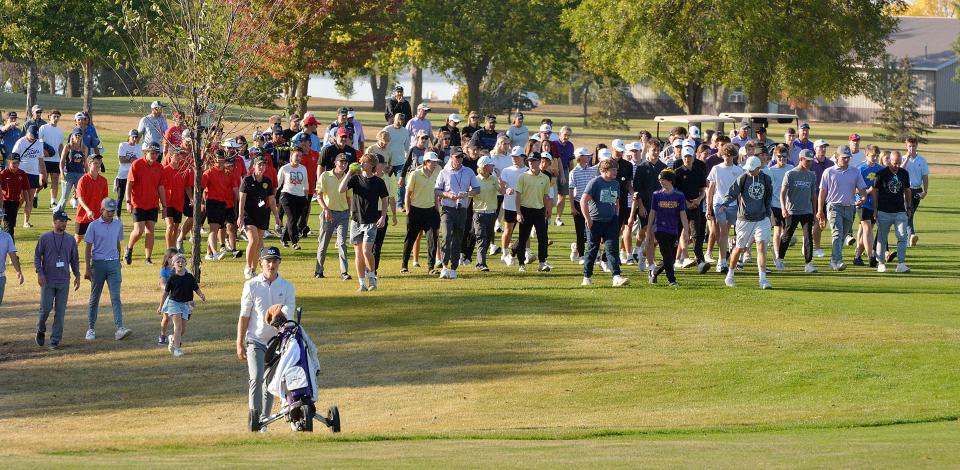 Ty Lenards of Watertown pushes his cart to the No. 1 Red green as a large gallery of fans follows during a playoff for the individual championship in the state Class AA high school boys golf tournament that concluded on Tuesday, Oct. 8, 2024, at Cattail Crossing Golf Course. Lenards won the playoff on the first hole and also helped Watertown repeat as the team champion.