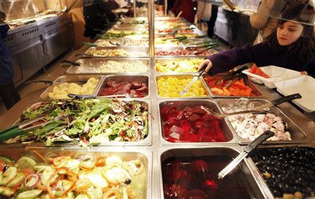 A girl helps herself to a buffet at a fast food restaurant in Harlem in New York December 16, 2009. N REUTERS/Finbarr O'Reilly