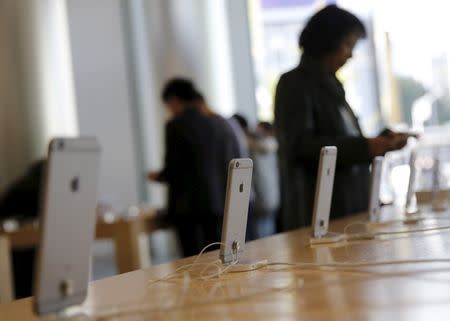 A woman tries apple's iPhone 6 at an Apple store in Beijing, November 2, 2015. REUTERS/Kim Kyung-Hoon