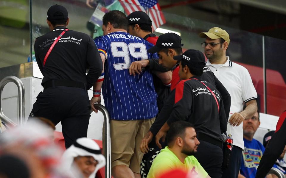  A USA fan wearing a Rainbow Armband is seen leaving the stadium alongside local security prior to the FIFA World Cup Qatar 2022 Group B match between IR Iran and USA at Al Thumama Stadium on November 29, 2022 in Doha, Qatar. - Getty Images