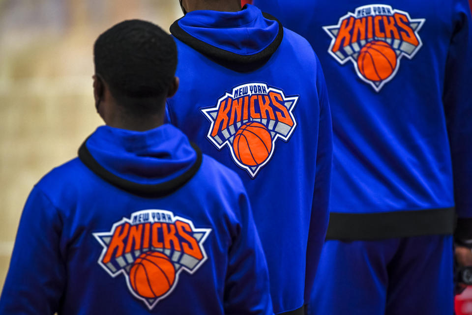 Knicks players wearing hoodies featuring the Knicks logo.