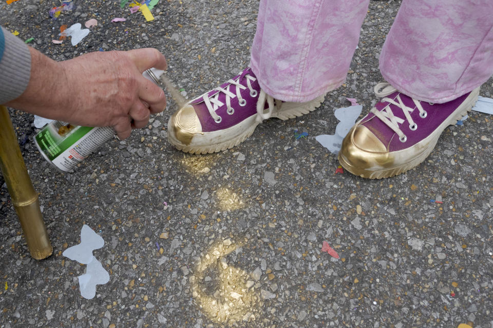 Gold paint paves the street and shoes for costumes during the Society of Saint Anne parade through Bywater and Marigny neighborhoods on Mardi Gras Day in New Orleans, Tuesday, Feb. 13, 2024. (AP Photo/Matthew Hinton)