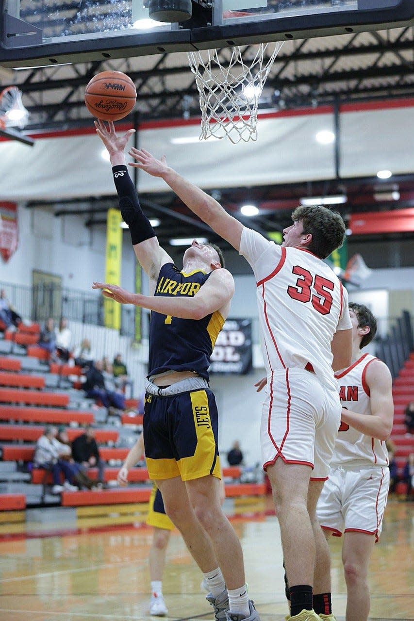 Airport’s Joel Westaway gets off a shot over a block attempt by Connor Dessellier of Milan during a 45-37 Airport win Tuesday night.