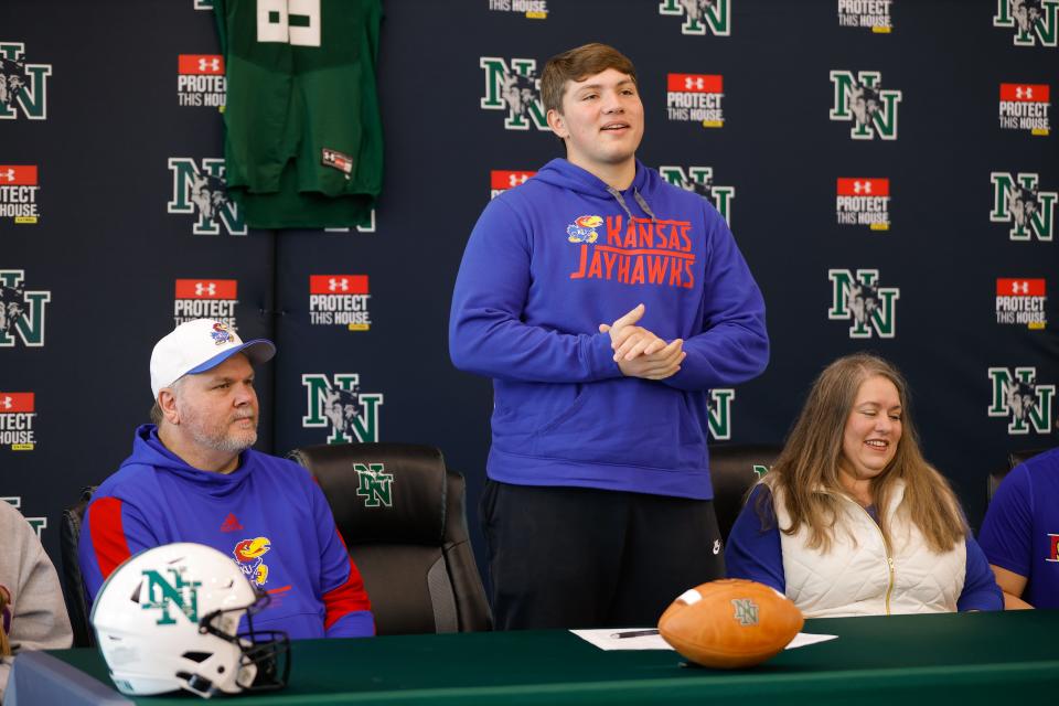 Norman North's Harrison Utley, surrounded by his dad, Terry, left, and mother, Carrie, speaks after signing to play football for Kansas as his mother, Carrie, watches during a signing day ceremony in Norman, Okla., Wednesday, Dec. 20, 2023.