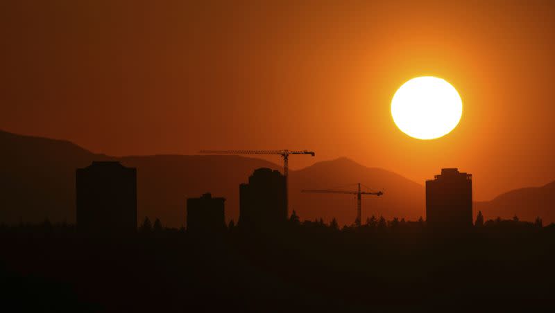 The sun sets over the University District in Seattle, Saturday, May 13, 2023, as seen from 520 Bridge View Park in Medina, Wash. Saturday’s temperatures reached record-breaking highs for several cities across western Washington, with a heat advisory in effect until Monday evening. 
