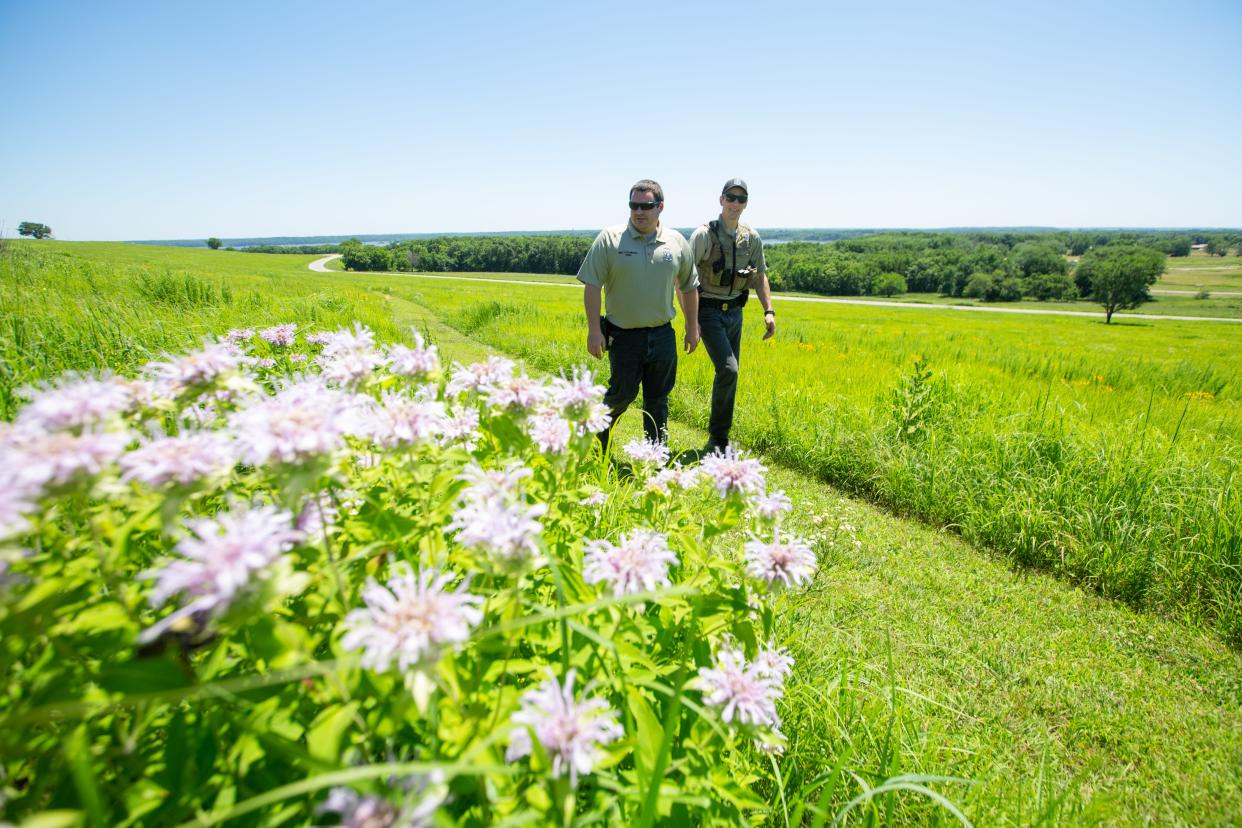 Clinton State Parks director  Conner O'Flannagan, left, walks alongside park ranger Chris Orton, right, Wednesday afternoon towards Bunker Hill on the north end of the 1500 acre park in Lawrence.