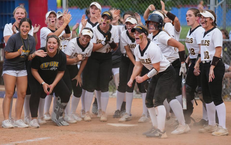 The Avon Orioles gather at the home plate to cheer for Avon Orioles Hannah Sutton (5) after a home run during the IHSAA class 4A regional championship on Tuesday, May 30, 2023, at Roncalli High School in Indianapolis. The Roncalli Royals defeated the Avon Orioles, 9-1. 