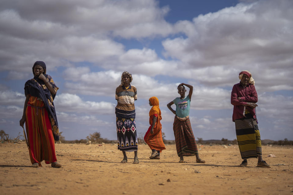 Men and women stand at a camp for displaced people on the outskirts of Dollow, Somalia, on Monday, Sept. 19, 2022. Somalia is in the midst of the worst drought anyone there can remember. A rare famine declaration could be made within weeks. Climate change and fallout from the war in Ukraine are in part to blame. (AP Photo/Jerome Delay)