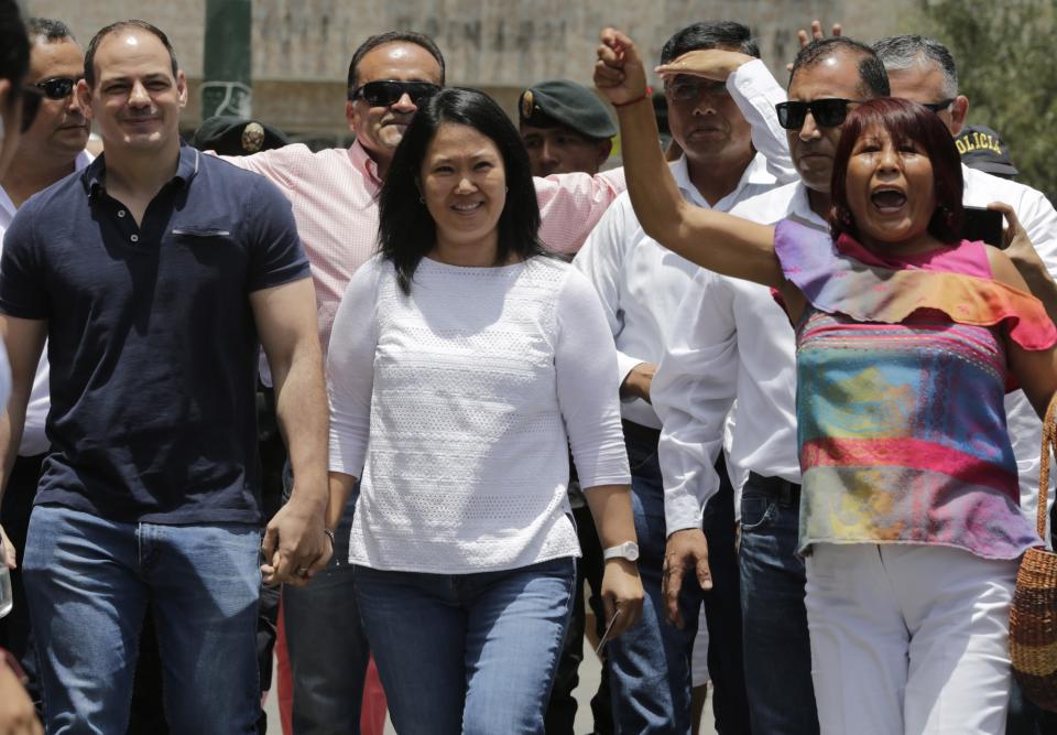 Keiko Fujimori, the daughter of Peru's former President Alberto Fujimori, and leader of the opposition party, center, with her husband Mark Vito Villanela, left, arrive to vote during congressional elections in Lima, Peru, Sunday, Jan. 26, 2020. Peruvians are voting to elect 130 new members of the congress that will legislate for only one year in place of the congress that was dissolved by president Martin Vizacarra in September 2019. (AP Photo/Martin Mejia)