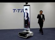 An employee of Toyota Motor Corp. demonstrates T-TR1 remote location communication robot which will be used to support the Tokyo 2020 Olympic and Paralympic Games, during a press preview in Tokyo