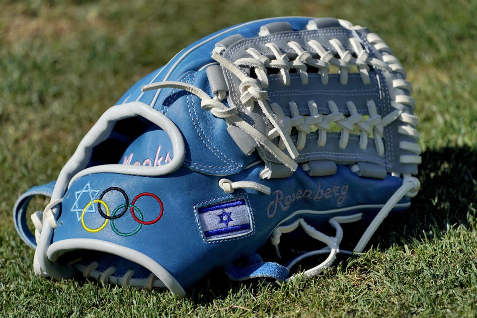 The glove of Israel Olympic baseball player Jake Roseberg sits on the field at Salt River Fields spring training facility, Wednesday, May 12, 2021, in Scottsdale, Ariz. Israel has qualified for the six-team baseball tournament at the Tokyo Olympic games which will be its first appearance at the Olympics in any team sport since 1976. (AP Photo/Matt York)