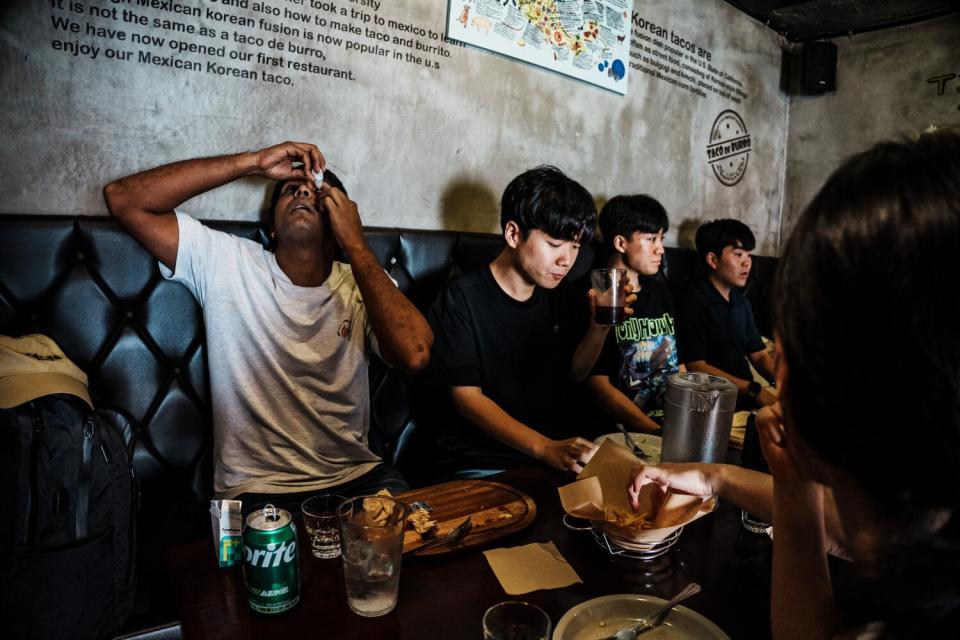 Ajit Roy, far left, waters his eyes as he dines with his friends from church.