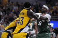 Milwaukee Bucks' Bobby Portis (9) shoves Indiana Pacers' Andrew Nembhard, left, during the first half of Game 4 of the first round NBA playoff basketball series, Sunday, April 28, 2024, in Indianapolis. (AP Photo/Michael Conroy)