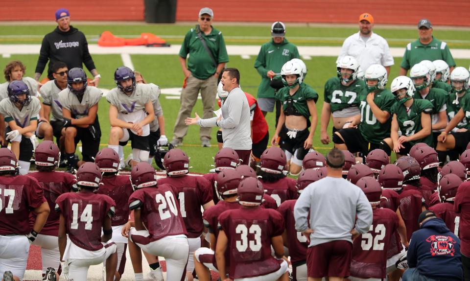 South Kitsap head coach Sean Banks, center, addresses the teams (South Kitsap, North Kitsap, Bainbridge and Peninsula) that gathered to take part in the South Kitsap spring football scrimmage in Port Orchard on June 14.