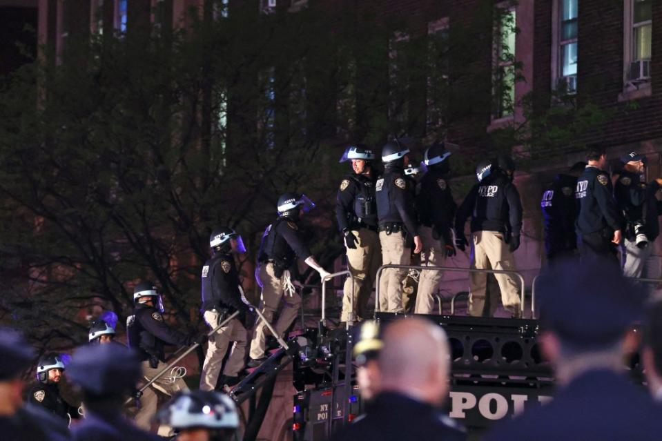 NYPD officers in riot gear wait to break into a building at Columbia University, where pro-Palestinian students are barricaded inside a building and have set up an encampment. AFP via Getty Images