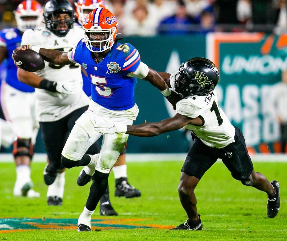 Florida Gators quarterback Emory Jones (5) pushes off on UCF Knights defensive back Corey Thornton (14).