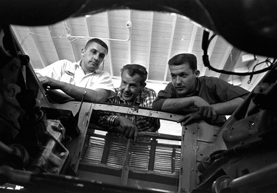 Lee Petty, center, 50-year-old head of the most successful family in stock car racing, and his sons look into empty engine well of a new race car on July 15, 1964.  In the shop with Petty at Level Cross, N.C., are Maurice, left, 25, an occasional driver whose main job is building engines and helping pit crews, and Richard, 26, the family's no. 1 driver since 1961 when Lee was crippled in an accident at the Daytona International Speedway.