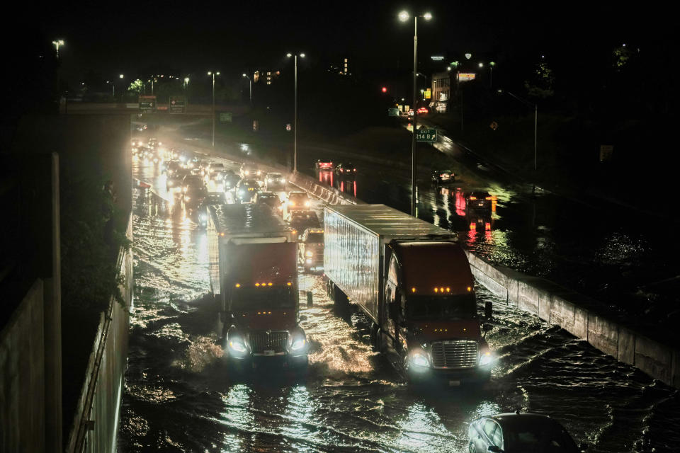 Vehicles cautiously drive through floodwaters on I-94 following a severe storm system that caused flash flooding on main roadways in Detroit.