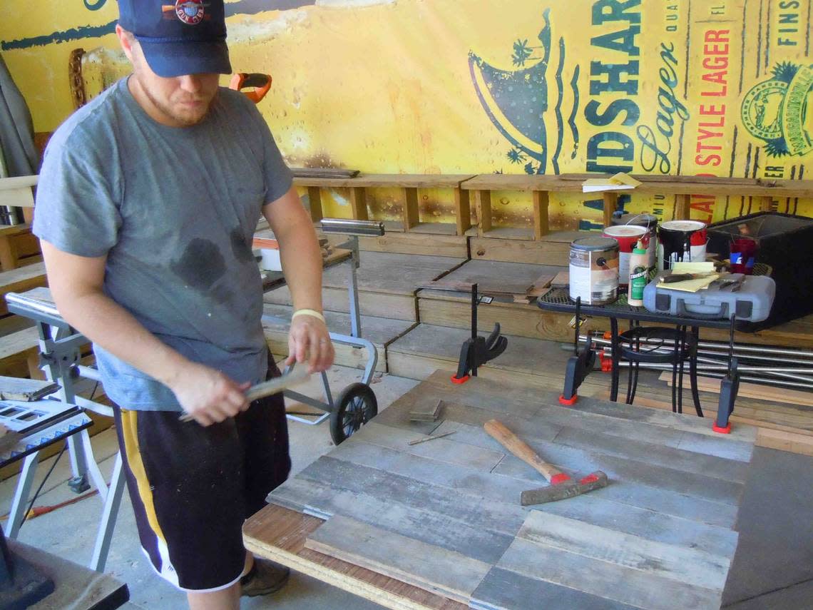 Travis Russell is pictured before Public at the Brickyard opened making tables for the restaurant using wood salvaged from a defunct St. Louis brewery.
