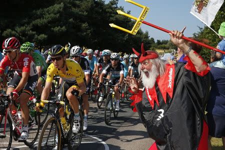 Etixx-Quick Step rider Tony Martin of Germany (C), race leader's yellow jersey, makes its way past Didi Senft, a cycling enthusiast better known as 'El Diablo' (The Devil), during the 191.5-km (118.9 miles) 6th stage of the 102nd Tour de France cycling race from Abbeville to Le Havre, France, July 9, 2015. REUTERS/Benoit Tessier