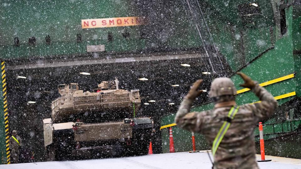 A U.S. Army soldier signals the way to an M1A2 Abrams tank that will be used for military exercises. The equipment arrived in Poland as part of Operation Atlantic Resolve, augmenting military presence along NATO's eastern front. (Mateusz Slodkowski/AFP via Getty Images)