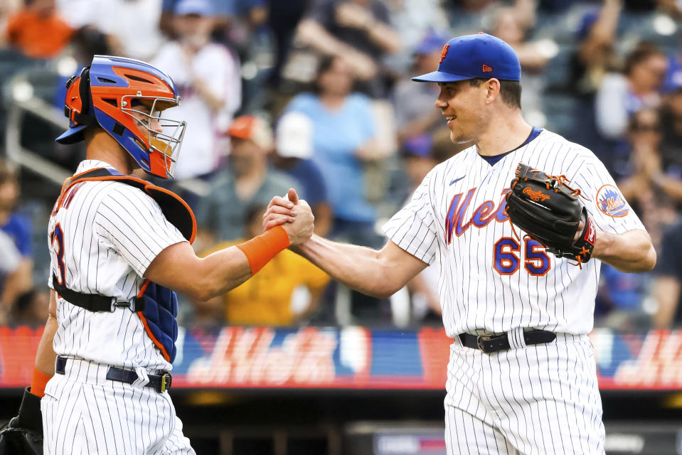 New York Mets' relief pitcher Trevor May shakes hands with catcher Tomas Nido after they defeated the Pittsburgh Pirates in a baseball game, Sunday, Sept. 18, 2022, in New York. (AP Photo/Julia Nikhinson)