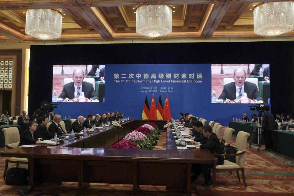 Screens show German Finance Minister Olaf Scholz speak during the China-Germany High Level Financial Dialogue with Chinese Vice Premier Liu He at the Diaoyutai State Guesthouse in Beijing, Friday, Jan. 18, 2019. (AP Photo/Andy Wong, Pool)