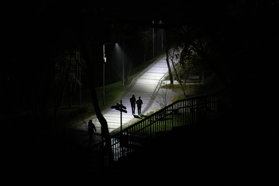 People walk in a park during a blackout in Kyiv on Sunday (AP)