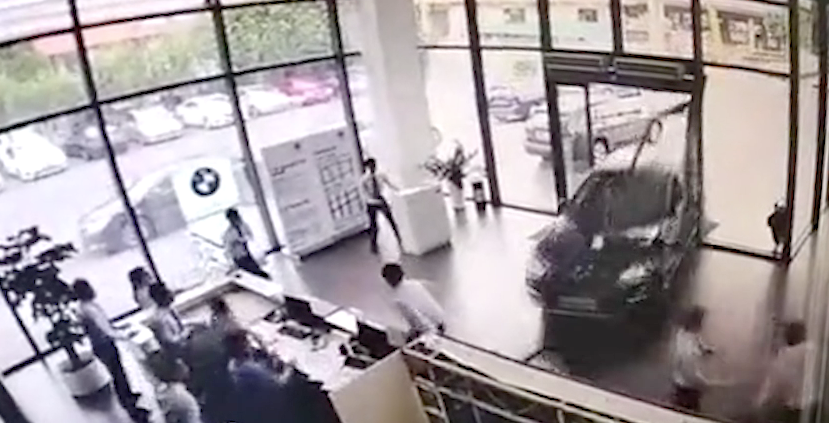 CCTV shows the woman plowing through the doors of the dealership with workers scattering before her. Photo: Australscope