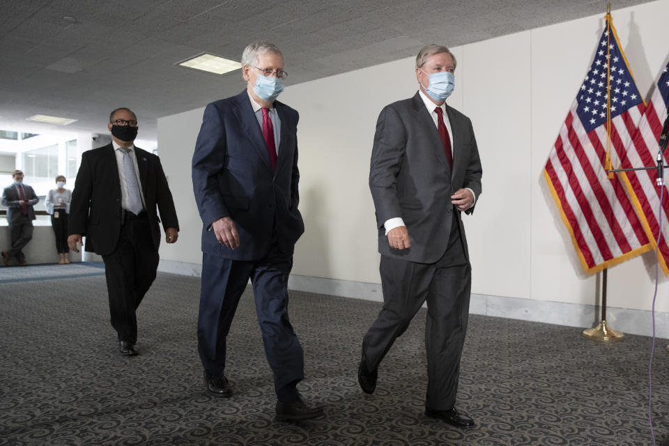 Senate Majority Leader Mitch McConnell of Ky., left, and Sen. Lindsey Graham, R-S.C., wear face masks to protect against the spread of the new coronavirus as they arrive for a weekly luncheon on Capitol Hill in Washington, Tuesday, May 19, 2020. (AP Photo/Patrick Semansky)