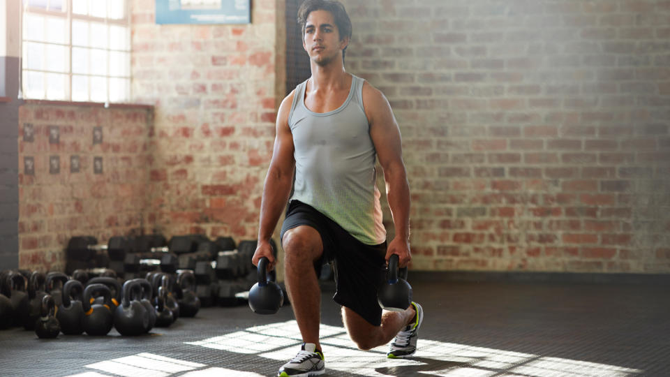 Man lunging while carrying two kettlebells