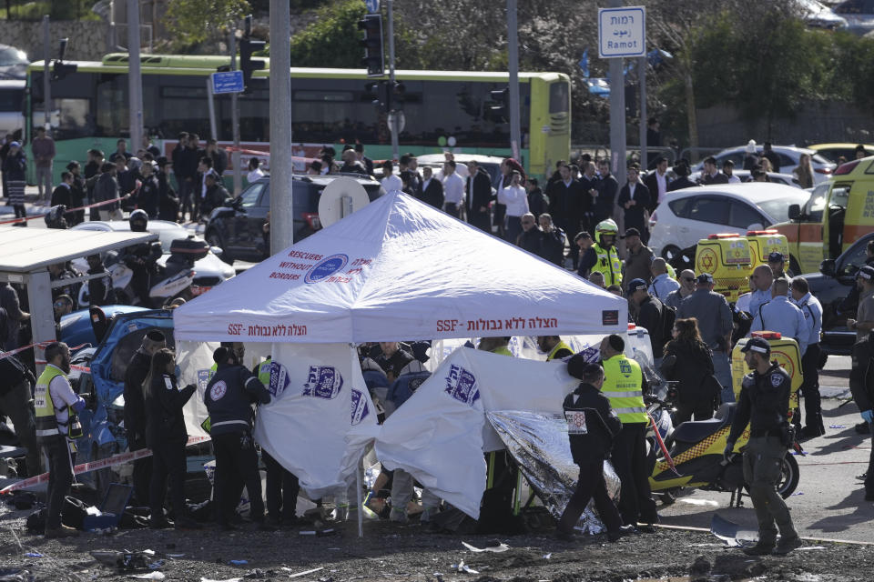 Members of Zaka Rescue and Recovery team work at the site of a car-ramming attack at a bus stop in Ramot, a Jewish settlement in east Jerusalem, Friday, Feb. 10, 2023. A suspected assailant rammed his car into several pedestrians in east Jerusalem on Friday. Police said that the suspected attacker was shot at the scene. There was no immediate word on his condition. Police identified the ages of the injured children as 5 and 6. (AP Photo/Mahmoud Illean)