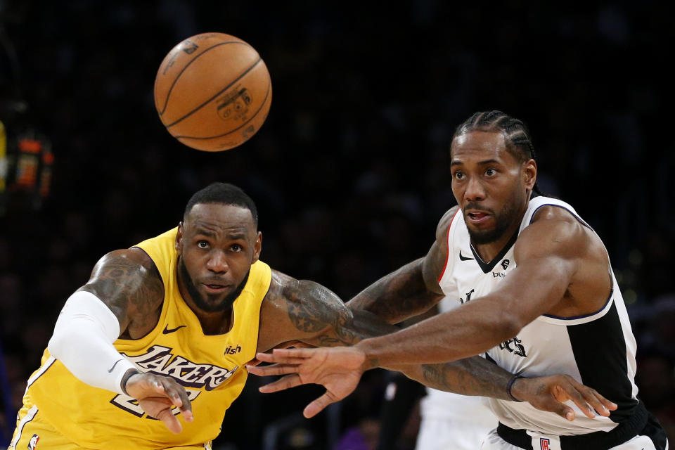 Los Angeles Lakers' LeBron James, left, and Los Angeles Clippers' Kawhi Leonard (2) chase the ball during the second half of an NBA basketball game Wednesday, Dec. 25, 2019, in Los Angeles. The Clippers won 111-106. (AP Photo/Ringo H.W. Chiu)