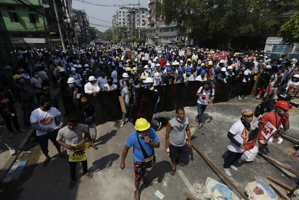 Demonstrators hold shields as they face riot police (EPA)