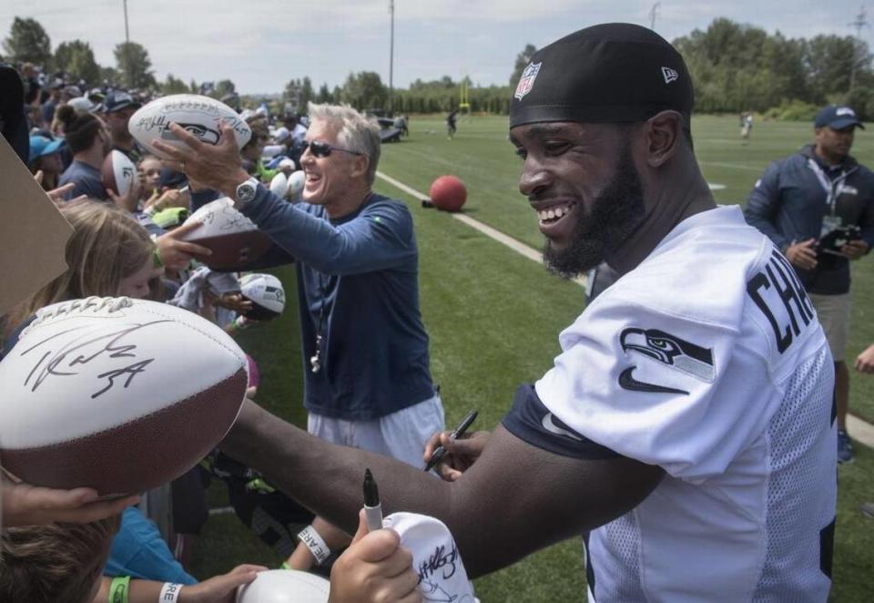 Seattle Seahawks head coach Pete Carroll and safety Kam Chancellor sign autographs for fans following the practice on the opening day of training camp in 2016 at the team’s Virginia Mason Athletic Complex in Renton.