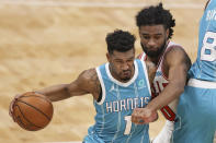 Charlotte Hornets guard Malik Monk, left, drives against Chicago Bulls guard Coby White during the first half of an NBA basketball game in Charlotte, N.C., Thursday, May 6, 2021. (AP Photo/Nell Redmond)