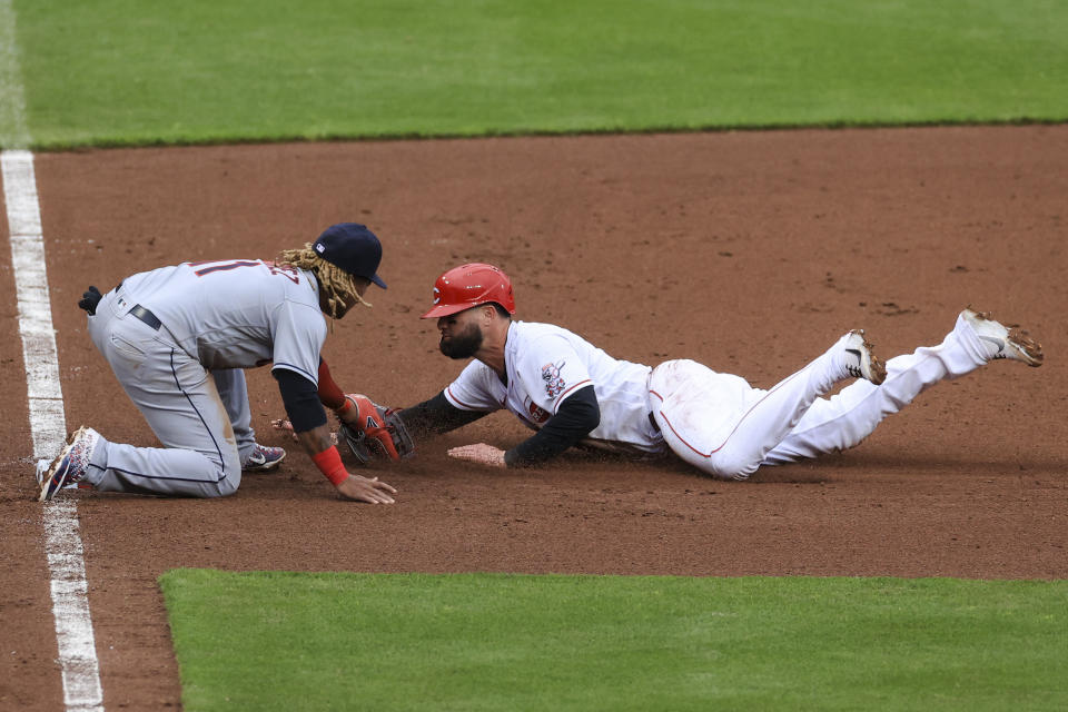 Cleveland Indians' Jose Ramirez, left, tags out Cincinnati Reds' Jesse Winker who was attempting to steal third base during the seventh inning of a baseball game in Cincinnati, Saturday, April 17, 2021. (AP Photo/Aaron Doster)